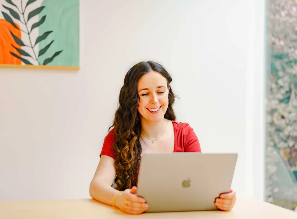 Maeve smiling as she works at her laptop
